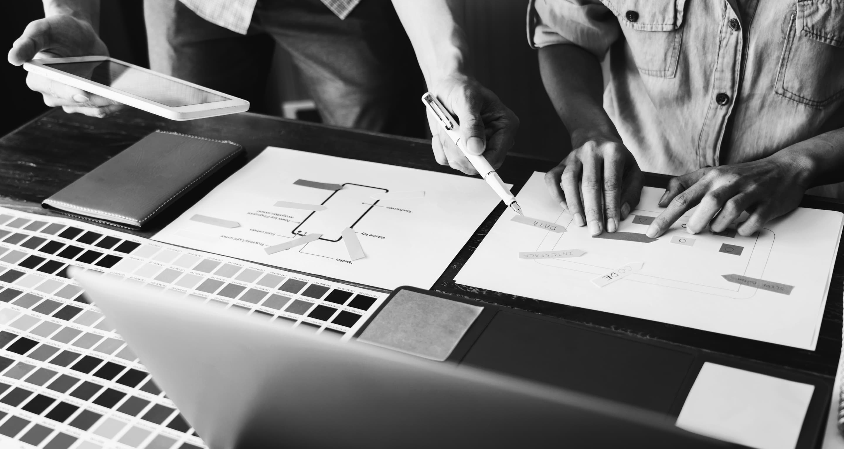 Black and white images of designers working on table